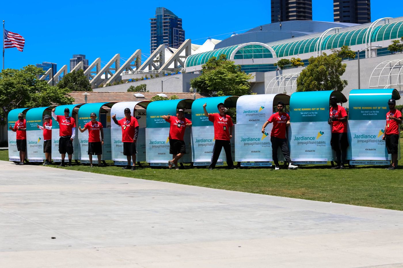VIP Pedicab drivers in red shirts standing with their cabs