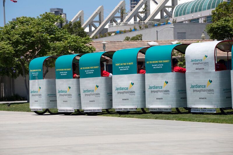 A row of branded pedicabs outside the Convention Center