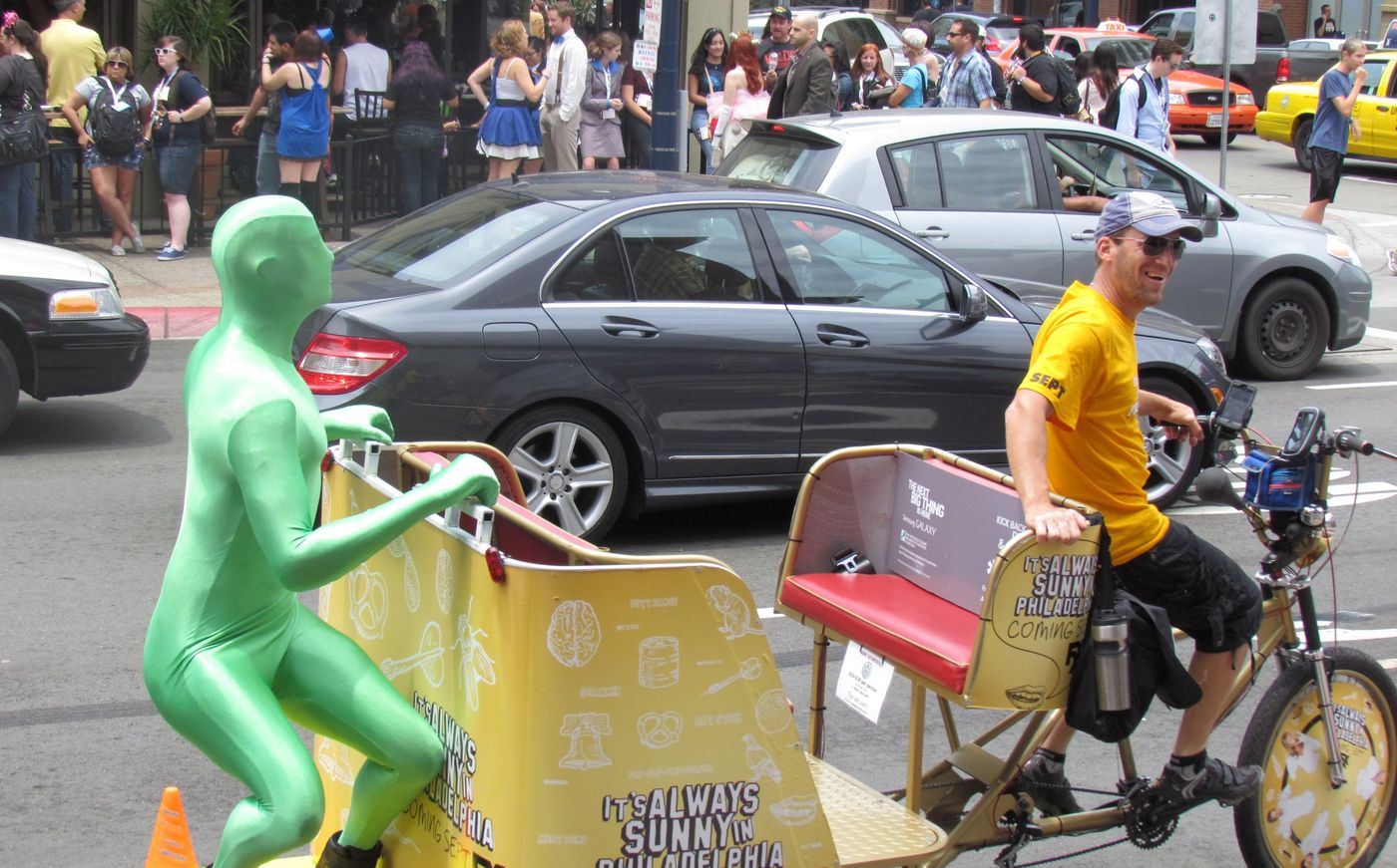 A smiling VIP driver pedaling through the Gaslamp during Comic-Con
